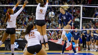 San Diego's Katie Lukes (18) spikes the ball against Texas' Saige Ka'aha'aina-Torres (9) in the second set during the semifinals of the NCAA volleyball tournament, Dec. 15, 2022 in Omaha, Nebraska.