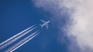 An Airbus A380 of Qatar Airways from the Emirate of Qatar flies over Frankfurt in the largely blue sky.