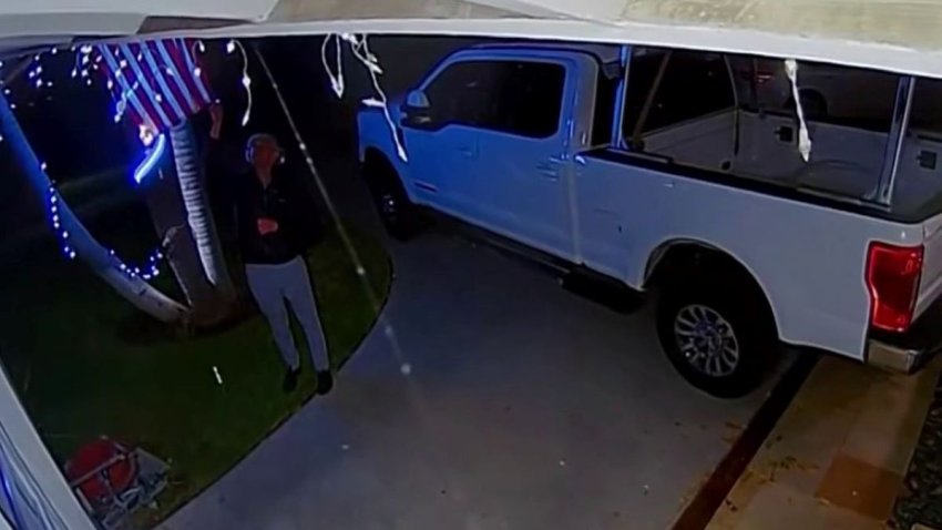 Security camera video shows a man lighting a U.S. flag on fire outside a Long Beach area home.