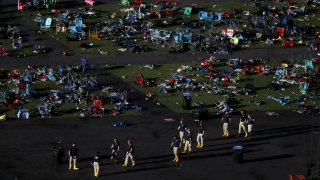 FILE – Investigators work at a festival grounds across the street from the Mandalay Bay Resort and Casino on Oct. 3, 2017, in Las Vegas after a mass shooting.