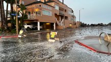 A street near Imperial Beach is flooded as storm surge reaches well beyond its usual tides.
