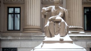 A statue sits covered in snow outside of the U.S. National Archives and Records Administration in Washington, D.C.