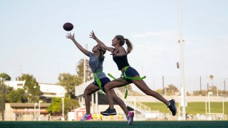 Syndel Murillo, 16, left, and Shale Harris, 15, reach for a pass as they try out for the Redondo Union High School girls flag football team on Thursday, Sept. 1, 2022, in Redondo Beach, Calif. California officials are expected to vote Friday on the proposal to make flag football a girls' high school sport for the 2023-24 school year.