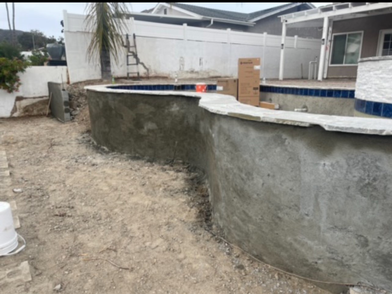 An unfinished pool in a backyard