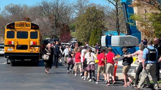 Children from The Covenant School, a private Christian school in Nashville, Tenn., hold hands as they are taken to a reunification site at the Woodmont Baptist Church after a deadly shooting at their school on Monday, March 27, 2023.