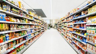 A colorful supermarket aisle withe no people but an abundance of food.