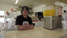 Sergio Becerra leans againt the counter at his family's restaurant.