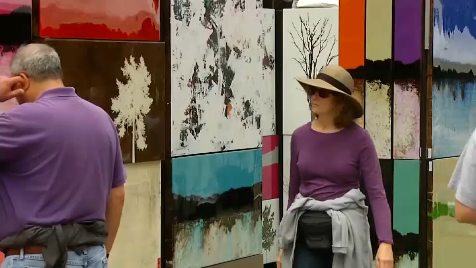 A woman takes a look at artwork at an Art Walk in Little Italy.