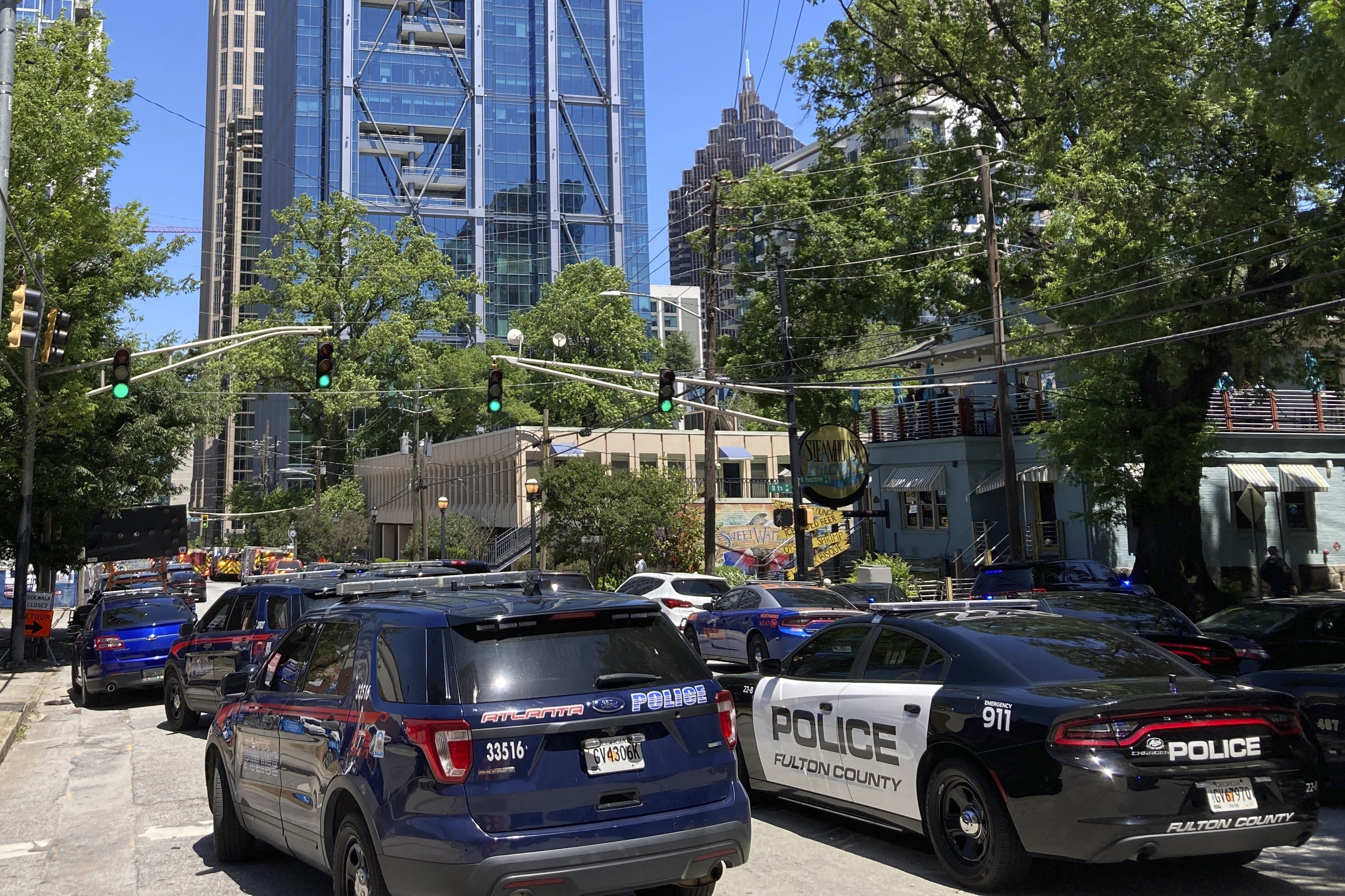 Emergency vehicles arrive on W. Peachtree in Atlanta, May 3, 2023. At least one person died, with three others injured, during a shooting in midtown Atlanta.