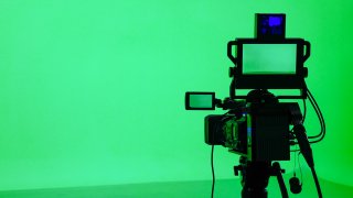 A generic TV camera in front of a green screen