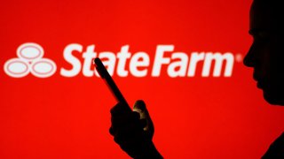 BRAZIL – 2022/06/28: In this photo illustration, the State Farm logo is seen in the background of a silhouetted woman holding a mobile phone. (Photo Illustration by Rafael Henrique/SOPA Images/LightRocket via Getty Images)