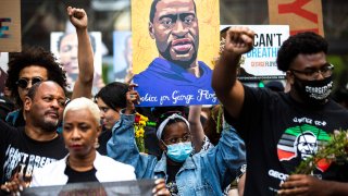 People raise their fists as they march during an event in remembrance of George Floyd in Minneapolis, Minnesota, on May 23, 2021.