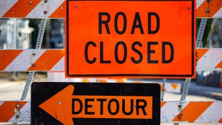 Road closed and detour signs w barrier up close