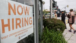 A ‘Now Hiring’ sign is displayed outside a resale clothing shop on June 2, 2023 in Los Angeles, California.