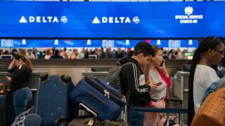 People wait in line at the Delta Air Lines check-in counter of JFK International airport in New York City, June 30, 2023.