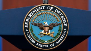 FILE – The seal of the Department of Defense is seen on the podium at the Pentagon, Sept. 27, 2022, in Washington. President Joe Biden will sign an executive order that gives decisions on the prosecution of serious military crimes, including sexual assault, to independent military attorneys, taking that power away from victims’ commanders.