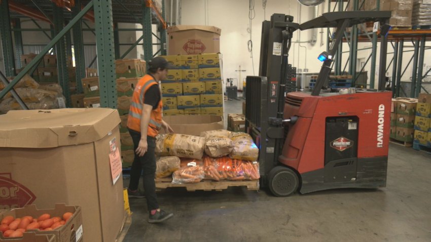 Forklift and a dude moving food in a warehouse.