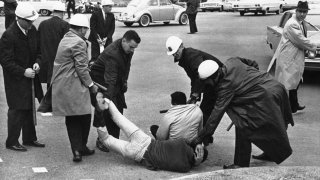 Police carry off two men who were part of a sit down group at Montgomery, Ala. on March 11, 1965