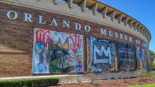 Signs for the Jean-Michel Basquiat exhibit outside the Orlando Museum of Art, on Friday, March 25, 2022.