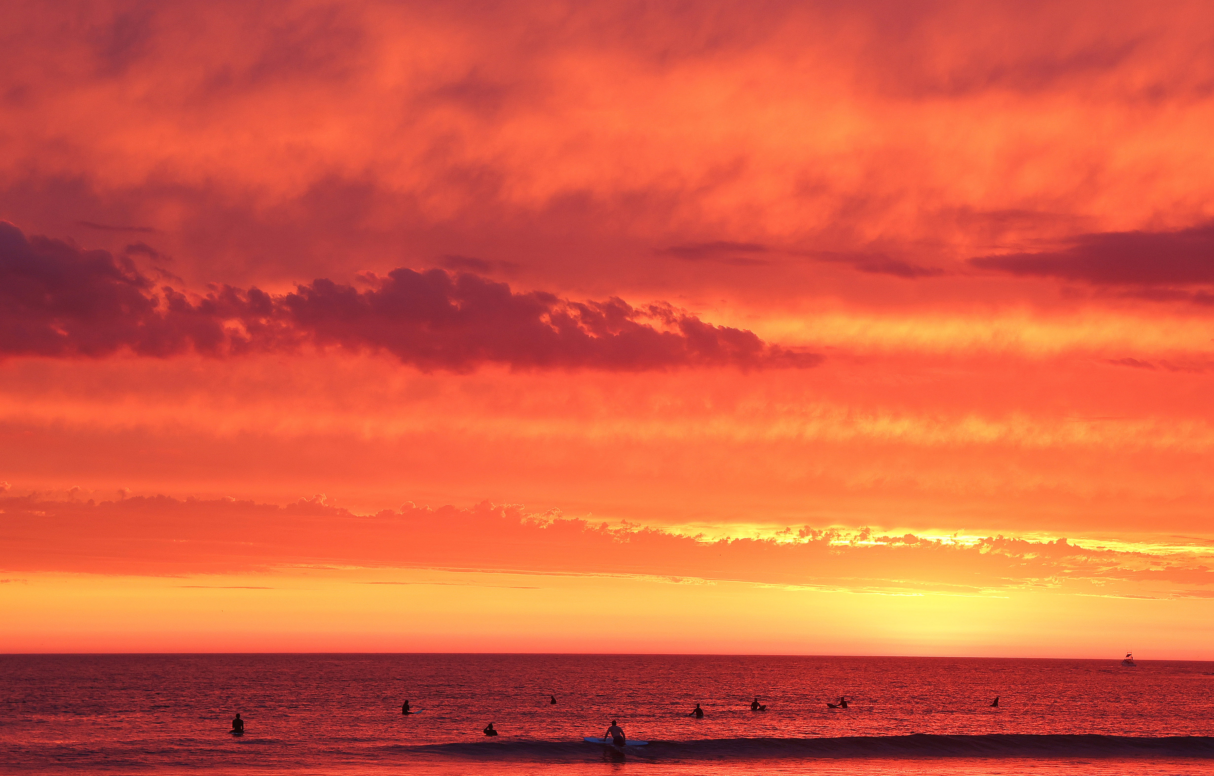 SAN DIEGO, CALIFORNIA – AUGUST 19: People surf as clouds pass shortly after sunset at Ocean Beach with Hurricane Hilary approaching on August 19, 2023 in San Diego, California. Southern California is under a first-ever tropical storm warning as Hurricane Hilary approaches with parts of California, Arizona and Nevada preparing for flooding and heavy rains. (Photo by Mario Tama/Getty Images)