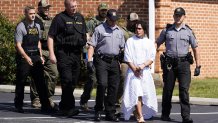 Danelo Cavalcante in a gown led by police after his arrest.