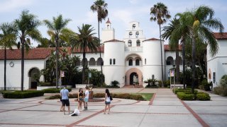 A student and her family pose for pictures on move-in day at San Diego State University in San Diego, on Aug. 21, 2020.