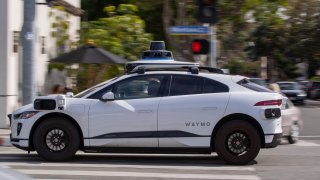 FILE - Passenger rides in an electric Waymo full self-driving technology in Santa Monica, Calif.