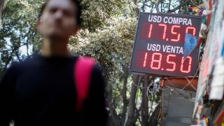 A board displays the exchange rates for Mexican Peso and U.S. Dollar in Mexico City, Mexico March 13, 2023.