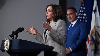 Education Secretary Miguel Cardona, at rear, listens as Vice President Kamala Harris speaks in Washington, D.C., June 2, 2022.