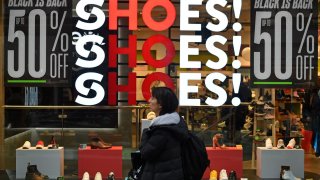 Shoppers pass a promotional sign for ‘Black Friday’ sales discounts in London, on November 23, 2018.