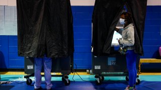 A voter looks from a booth while casting their ballot on election day in Philadelphia, Nov. 7, 2023.