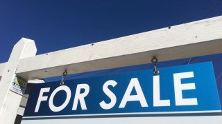A For Sale sign is shown against a bright blue sky in San Diego, Dec. 13, 2018.