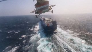 Houthi military helicopter flies over the Galaxy Leader cargo ship in the Red Sea in this photo released on Nov. 20, 2023.