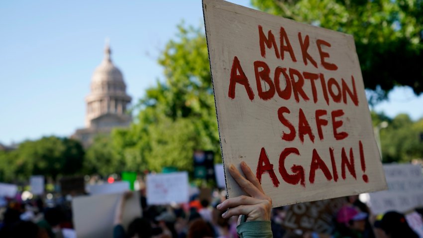 FILE - Demonstrators march and gather near the state capitol