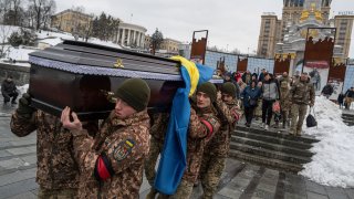 Honor guards carry the coffin of Ukrainian serviceman Andrii Trachuk during his funeral service on Independence square in Kyiv, Ukraine, Friday, Dec. 15, 2023.