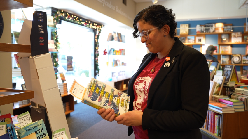 Amanda Qassar looks at a book in Warwick’s bookstore in La Jolla on Dec. 15, 2023.