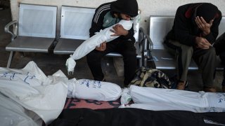 Palestinians mourn relatives killed in the Israeli bombardment of the Gaza Strip in Rafah, Saturday, Jan. 13, 2024.