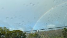 A rainbow arches over a hillside off Mission Gorge Road in San Diego, Jan. 11, 2023.
