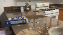 A box of Frosted Flakes sits on a muddy countertop in a home damaged by flooding in the Southcrest neighborhood of San Diego, Jan. 23, 2024.