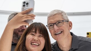 Tim Cook, chief executive officer of Apple Inc., takes a photograph with an attendee during an event at Apple Park campus in Cupertino, California, US, on Tuesday, Sept. 12, 2023. 