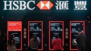 Customers use automated teller machines (ATM) at an HSBC Holdings Plc bank branch at night in Hong Kong, China, on Saturday, Feb 16, 2019.
