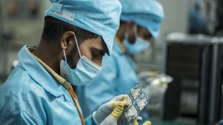 Workers inspect smart phone components at the visual inspection area of the surface mount technology workshop inside the Realme factory in Greater Noida, India: Anindito Mukerjee | Bloomberg | Getty Images