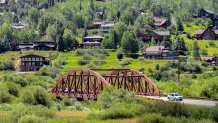 A motorist passes through a hillside community, Thursday, Aug. 4, 2022, in Steamboat Springs, Colo. The city council passed a rule in June that could prove to be a model for other vacation towns: A ban on new short-term rentals in most of the city and a ballot measure to tax bookings at 9% to fund affordable housing.