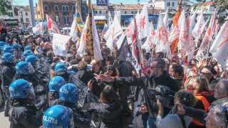 Demonstrators try to break through the blockade created by police officers to enter the city at Piazzale Roma, opposing the charge for tourists to enter the city on April 25, 2024 in Venice, Italy. Today Venice authorities launched a pilot program charging visitors a 5-euro entry fee in the hope that it will discourage at peak time, making the city more livable for its residents.