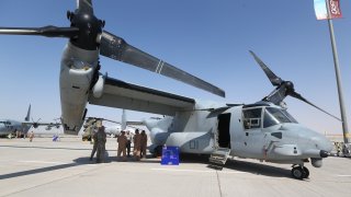 US soldiers stand in the shade of the wing of a Bell Boeing V-22 Osprey, a US multi-mission, tiltrotor military aircraft, displayed at the Dubai Airshow on November 8, 2015. Dubai Airshow took off today to a slow start amid little expectations of major orders to match the multi-billion-dollar sales generated at the last edition of the biennial fair. AFP PHOTO/MARWAN NAAMANI / AFP / MARWAN NAAMANI (Photo credit should read MARWAN NAAMANI/AFP via Getty Images)