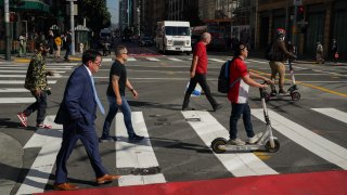 Pedestrians cross a downtown intersection in San Francisco.