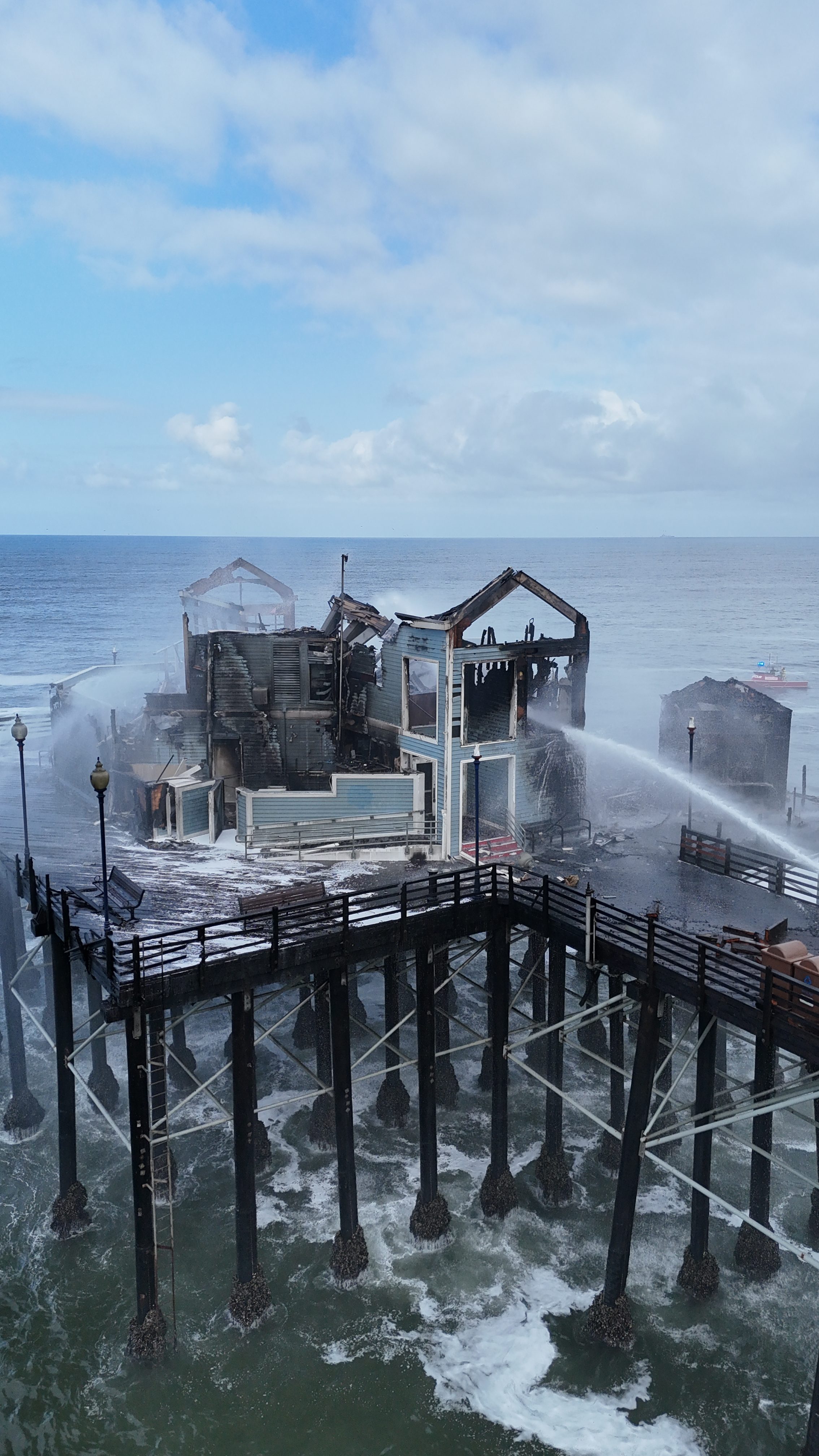 Fire crews continue putting out flames on April 26, 2024 that broke out on the Oceanside Pier. (Hunter Cochran)