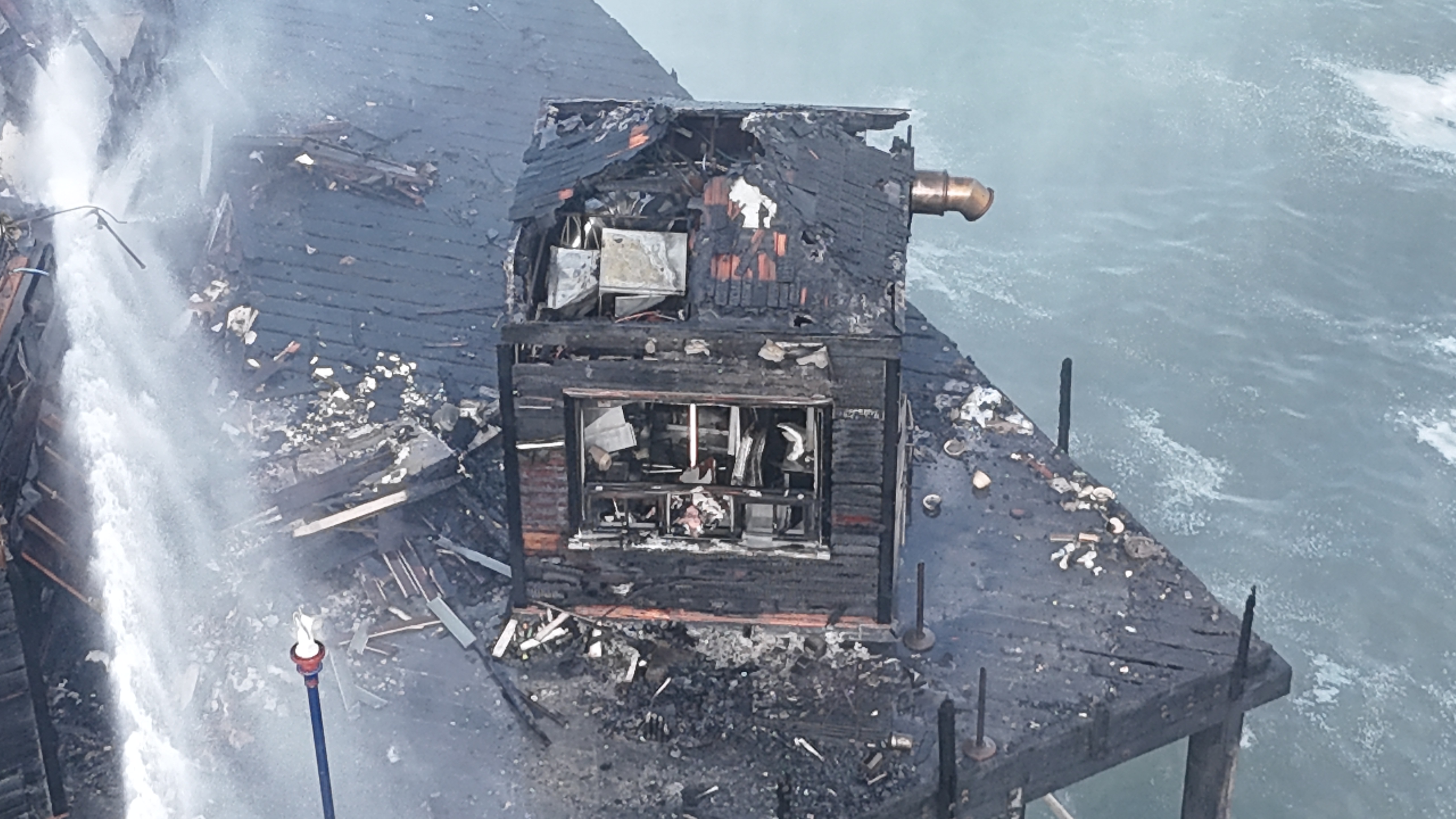 Fire crews continued containing flames on the Oceanside Pier on April 26, 2024 from a massive fire that broke out the day before. (Hunter Cochran)