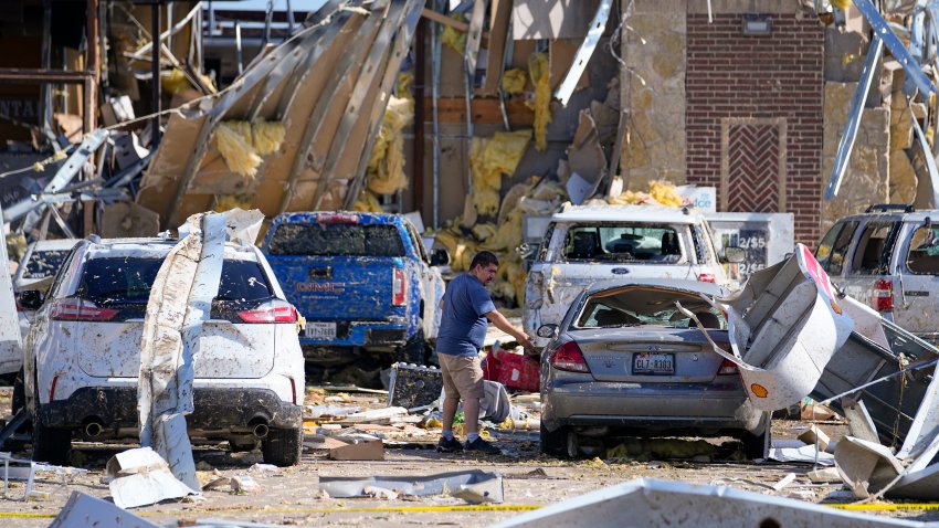 A man looks at a damaged car after a tornado hit the day before, Sunday, May 26, 2024, in Valley View, Texas. Powerful storms left a wide trail of destruction Sunday across Texas, Oklahoma and Arkansas after obliterating homes and destroying a truck stop where drivers took shelter during the latest deadly weather to strike the central U.S.