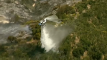 A chopper making a water drop over the brush fire that burned Monday near Alpine